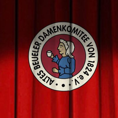 Das Altes Beueler Damenkomitee-Logo prangt auf einem roten Vorhang und feiert die Tradition von Weiberfastnacht.